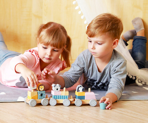 Polarb-stacking-train-pinoamisleikkisetti, jossa on erivärisiä ja -muotoisia junanvaunuja, kiskoja ja junanveturi.