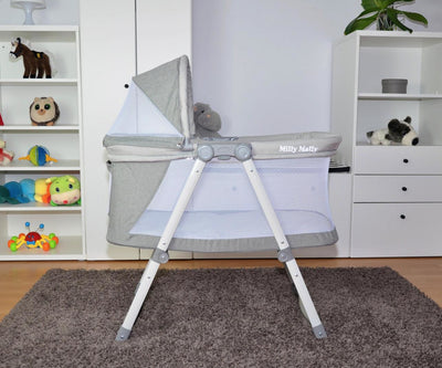 Beige vauvansänky, jossa on katos ja pyörät.