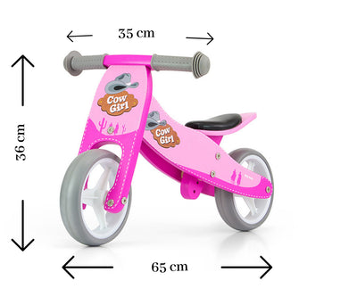 Milly Mally Ride-On 2in1 -tuote, Jake Cowgirl-malli. Musta ja valkoinen leikkiauto lapsille, jossa on hauska lehmäkuosi. Tuote toimii sekä kävely- että istumisleluna.