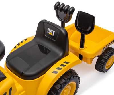 Kuvassa on punainen Caterpillar-traktori, jossa on isoja renkaita ja kauha edessä. Traktori seisoo ulkona hiekkapohjalla.