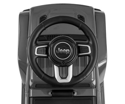 Harmaa Jeep Rubicon Gladiator -maasturi seisoo hiekkatiellä.