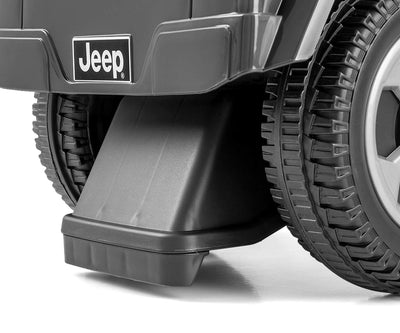Harmaa Jeep Rubicon Gladiator -maasturi seisoo ulkona asfaltilla.