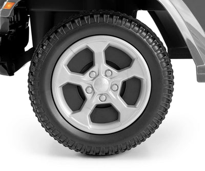 Harmaa Jeep Rubicon Gladiator -maasturi seisoo ulkona hiekkatiellä.