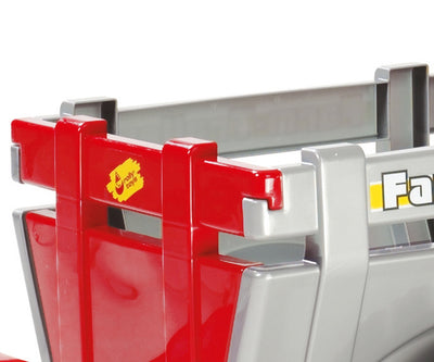 Punainen Rolly Toys -traktori juniorikokoisella perävaunulla.