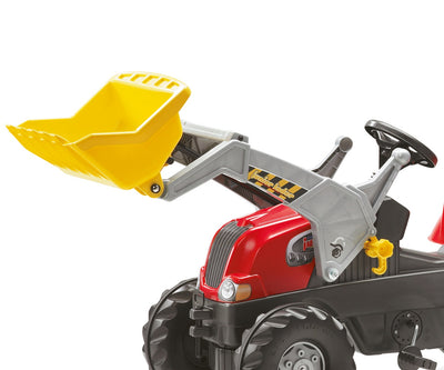 Punainen Rolly Toys -traktori juniorikokoisella perävaunulla ja lapiovarustuksella.