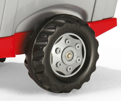 Punainen Rolly Toys -traktori junior-kokoelmaan kuuluvalla perävaunulla ja lapioilla.