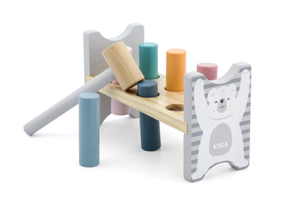 Vigatoysin Polar Bear Pound-a-Peg -lelu. Puinen vasara ja neljä värikästä nallekarhua, jotka on tarkoitus lyödä alas pelipöydälle. Tuote sopii hyvin motoristen taitojen kehittämiseen lapsille.