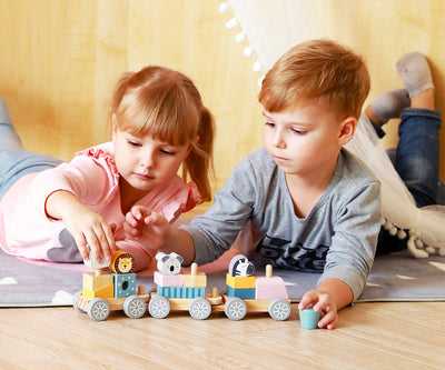 Polarb-stacking-train-pinoamisleikkisetti, jossa on erivärisiä ja -muotoisia junanvaunuja, kiskoja ja junanveturi.